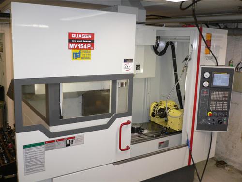En CNC-fräsmaskin utrustad med en digital kontrollpanel, säkerhetskapsling och varningsetiketter. Modellnummer MV154PL är synligt på maskinen.