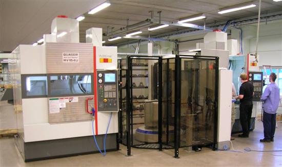 Två industriarbetare driver stora CNC-maskiner i en väl upplyst fabriksmiljö, med fokus på kontrollpanelerna för att övervaka den automatiserade bearbetningsprocessen.