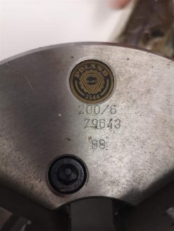 Närbild av ett metallföremål med en graverad rund logotyp läsning 