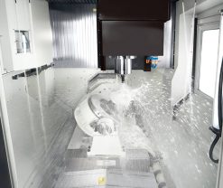 En Quaser UX500 i drift med kylvätska som sprutas på en roterande metalldel.