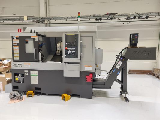En cnc-svarvmaskin i industriell miljö med verktyg och utrustning i närheten.