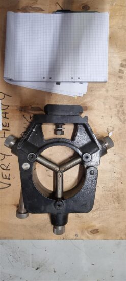 En Colchester-Harrison Fast stödlager 10-150 mm för Colchester Master, i svart metall med justerbara mässingsfingrar, vilar på trä bredvid rutat papper. Handskriften på ytan framhäver dess precisionsanvändning som en snabb stödlager.